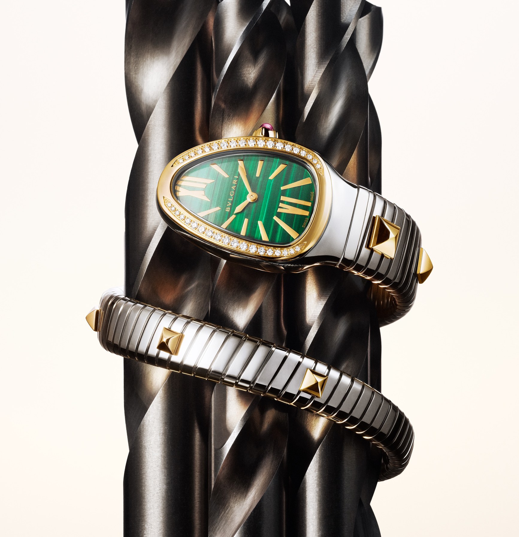 Bvlgari Serpenti Tubogas watch with malachite dial and diamond bezel coiled around a metal drill bit.