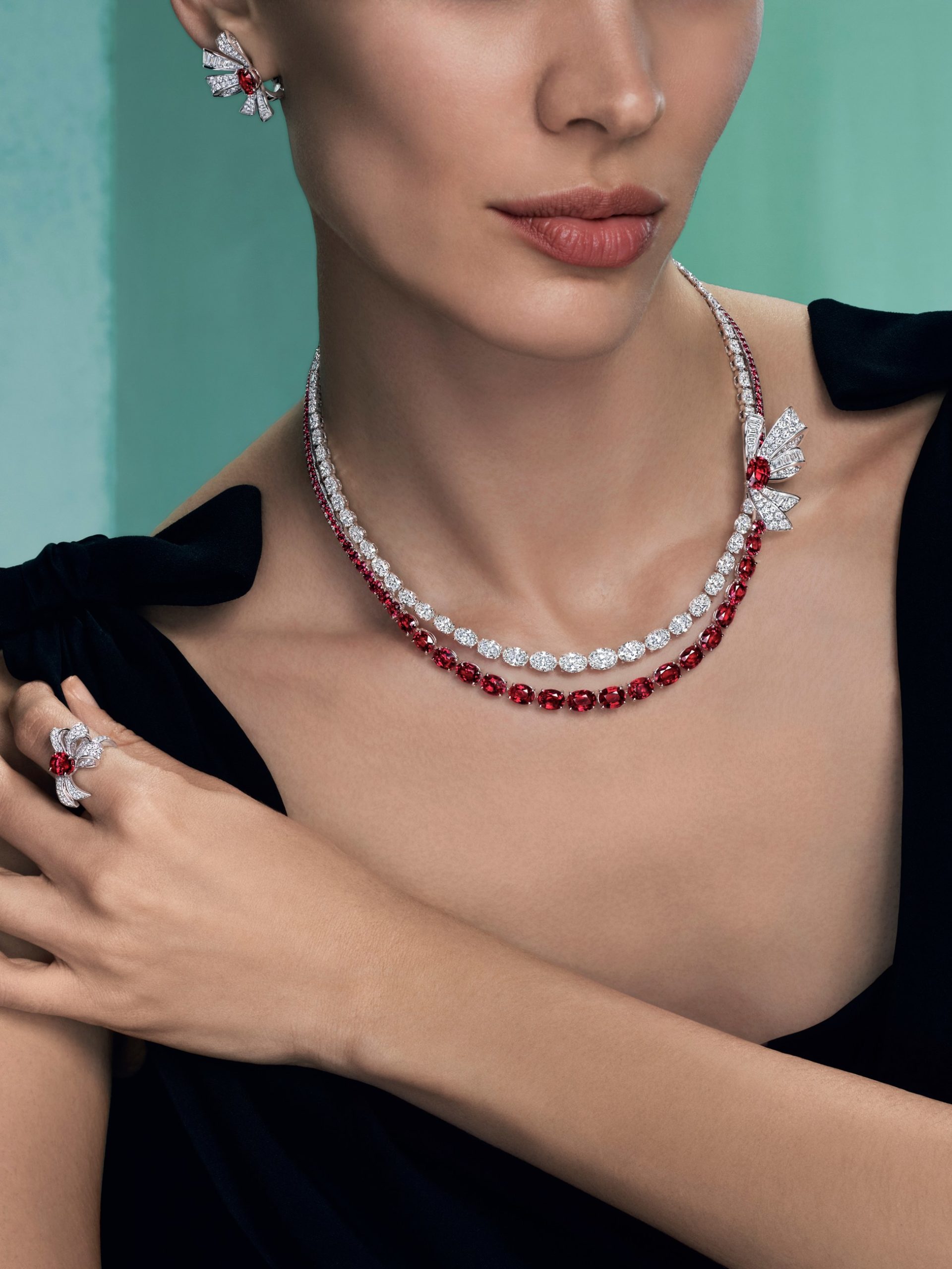 Model wearing Graff double-strand ruby and diamond necklace, bow earrings and ring in white gold.